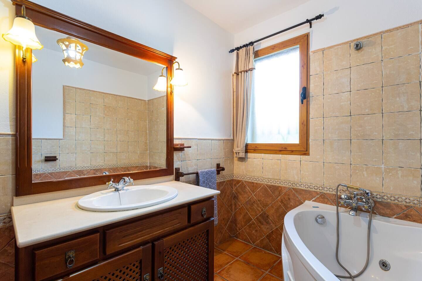 A bathroom with a sink, mirror, vanity, and bathtub.