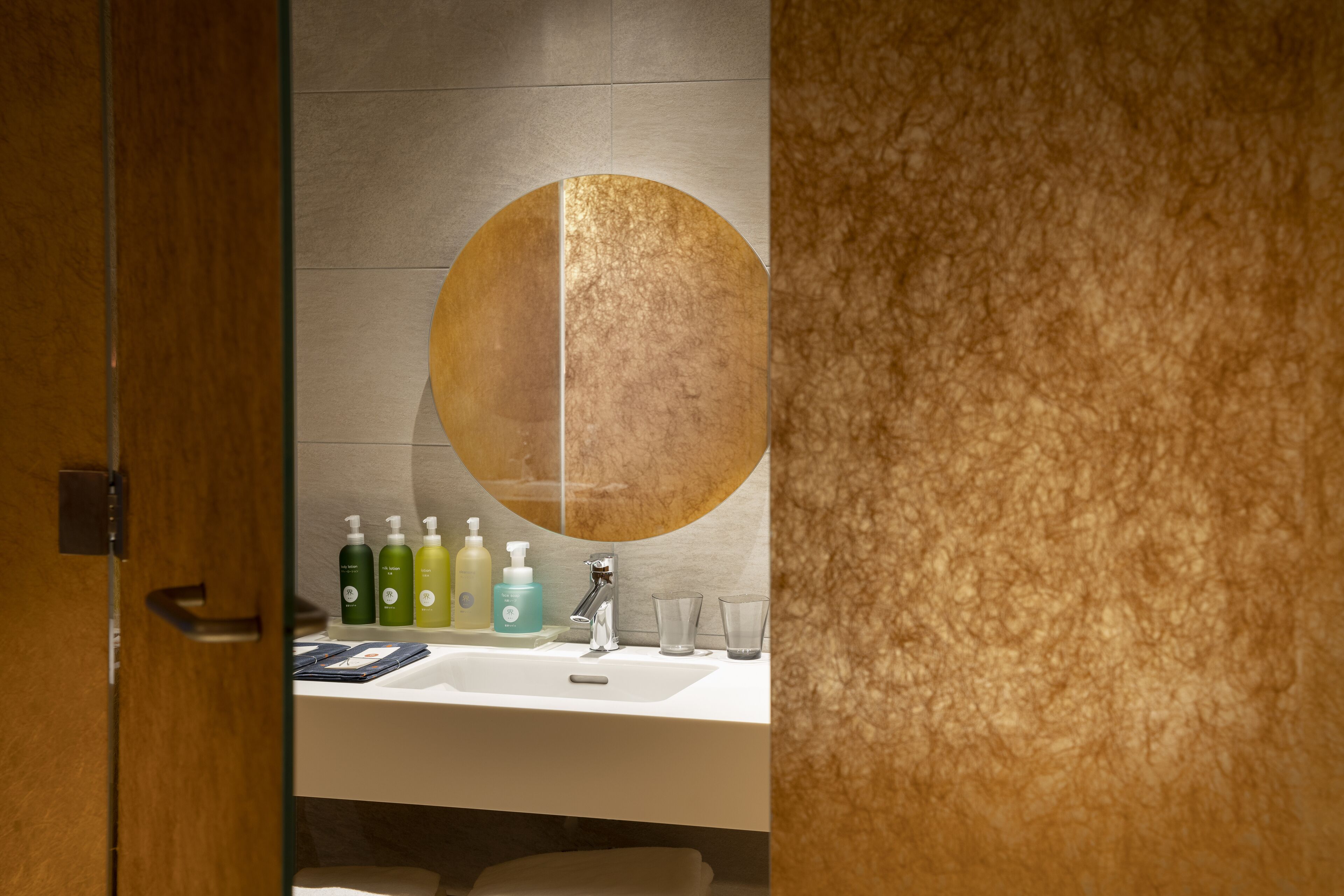Une salle de bain avec un grand miroir, un lavabo et des articles de toilette.