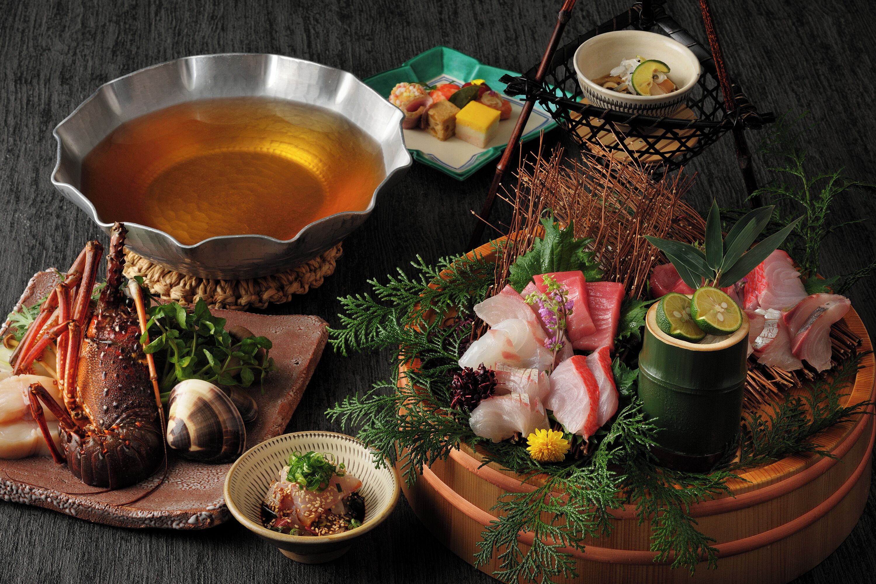 A variety of seafood and a bowl of soup on a wooden table.