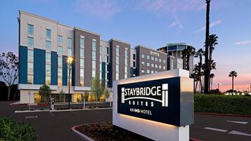 A Staybridge Suites Aning Hotel sign with a modern building in the background.