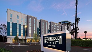 Staybridge Suites Aning -hotellin kyltti, jonka taustalla näkyy moderni rakennus.