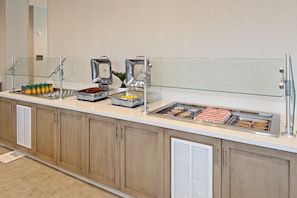 Een buffet met diverse gerechten en een koffieapparaat.