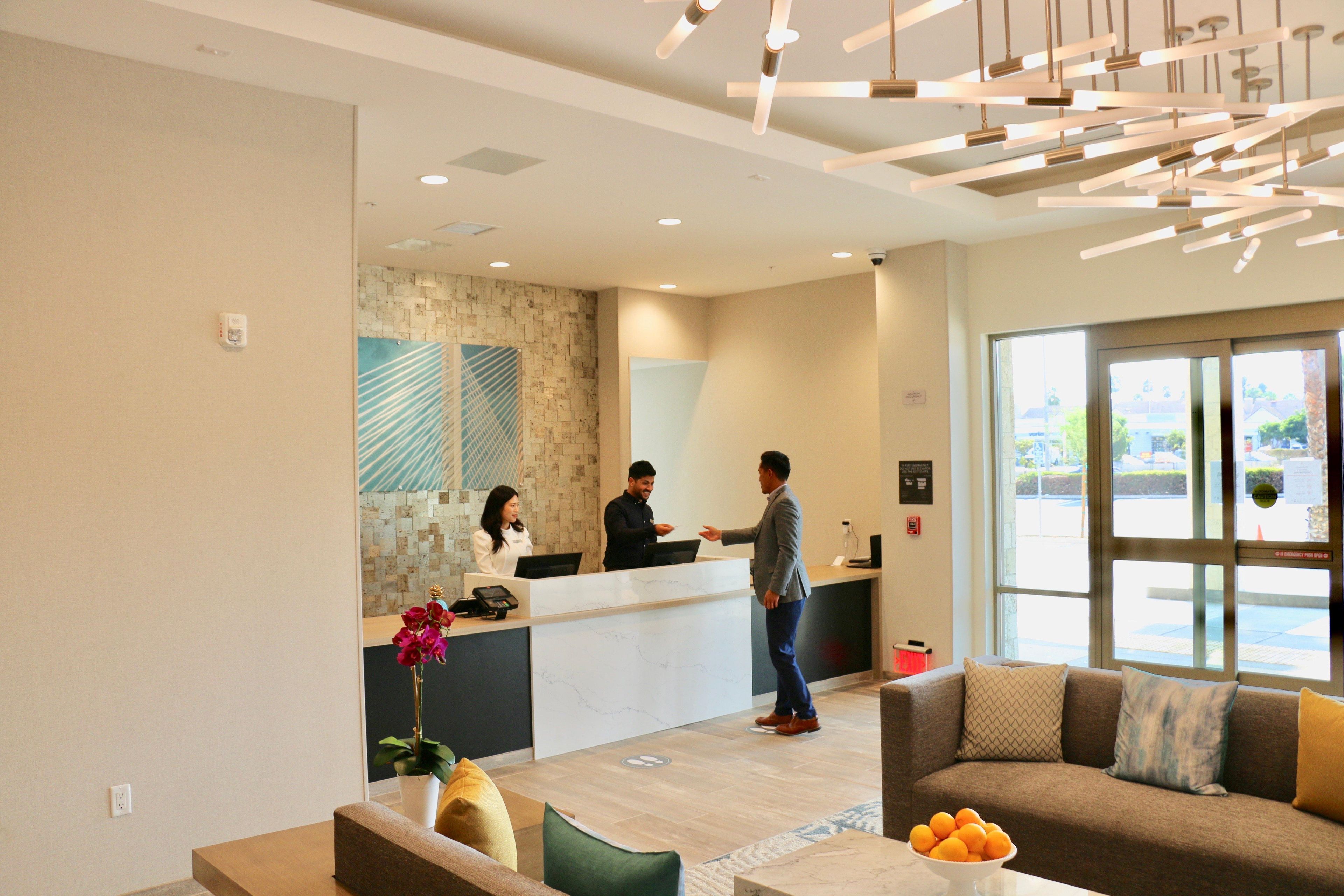 A reception area with a counter, a sofa, and a coffee table.