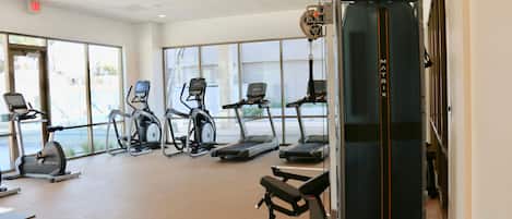 A gym with treadmills, elliptical machines, and weight equipment.