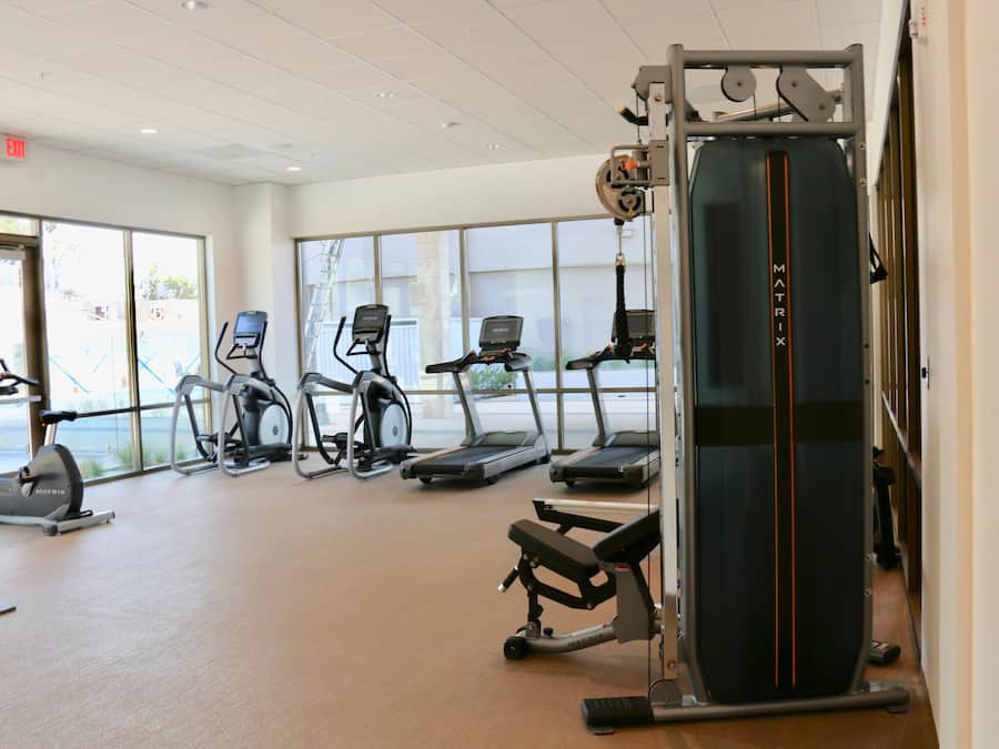 A gym with treadmills, elliptical machines, and weight equipment.