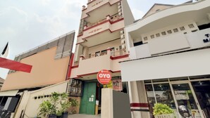 A multi-story building with a green door and a sign indicating a guesthouse.
