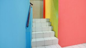 Eine Treppe mit weißen Stufen, umgeben von Wänden in Blau, Rot und Gelb.