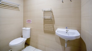 A small bathroom with a toilet, sink, and towel rack. - OYO 3754 Prosperity Mansion (Jakarta)