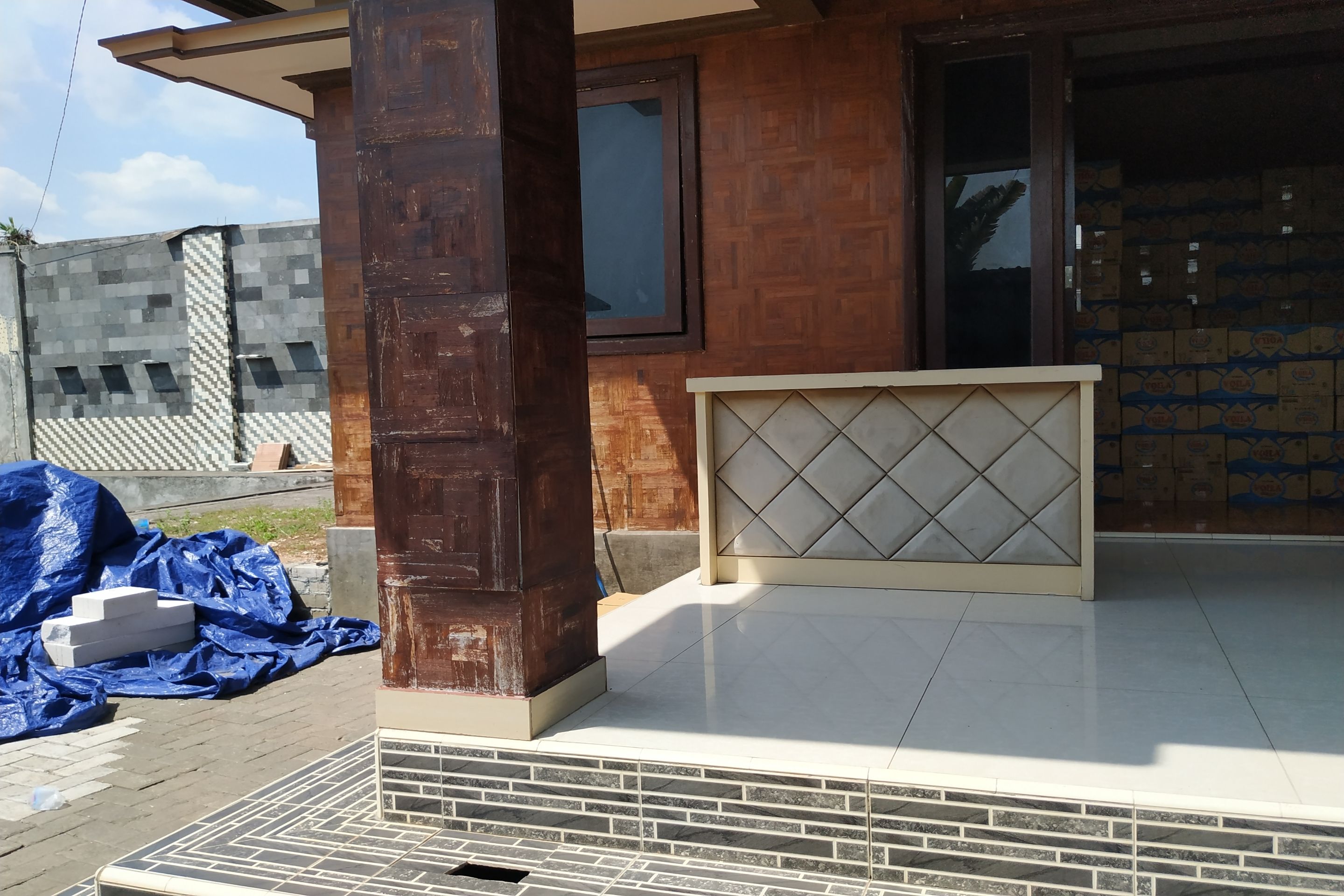 Un edificio con fachada de madera, entrada de cerámica y una ventana.