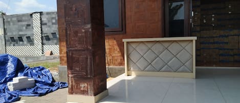 Un edificio con fachada de madera, entrada de cerámica y una ventana.
