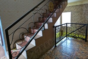 Una escalera con barandilla de metal decorativa y azulejos con diseño.