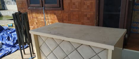 Una habitación con piso de baldosas, pared de madera y una ventana.