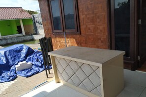 Una habitación con suelo de baldosas, pared de madera y ventana.