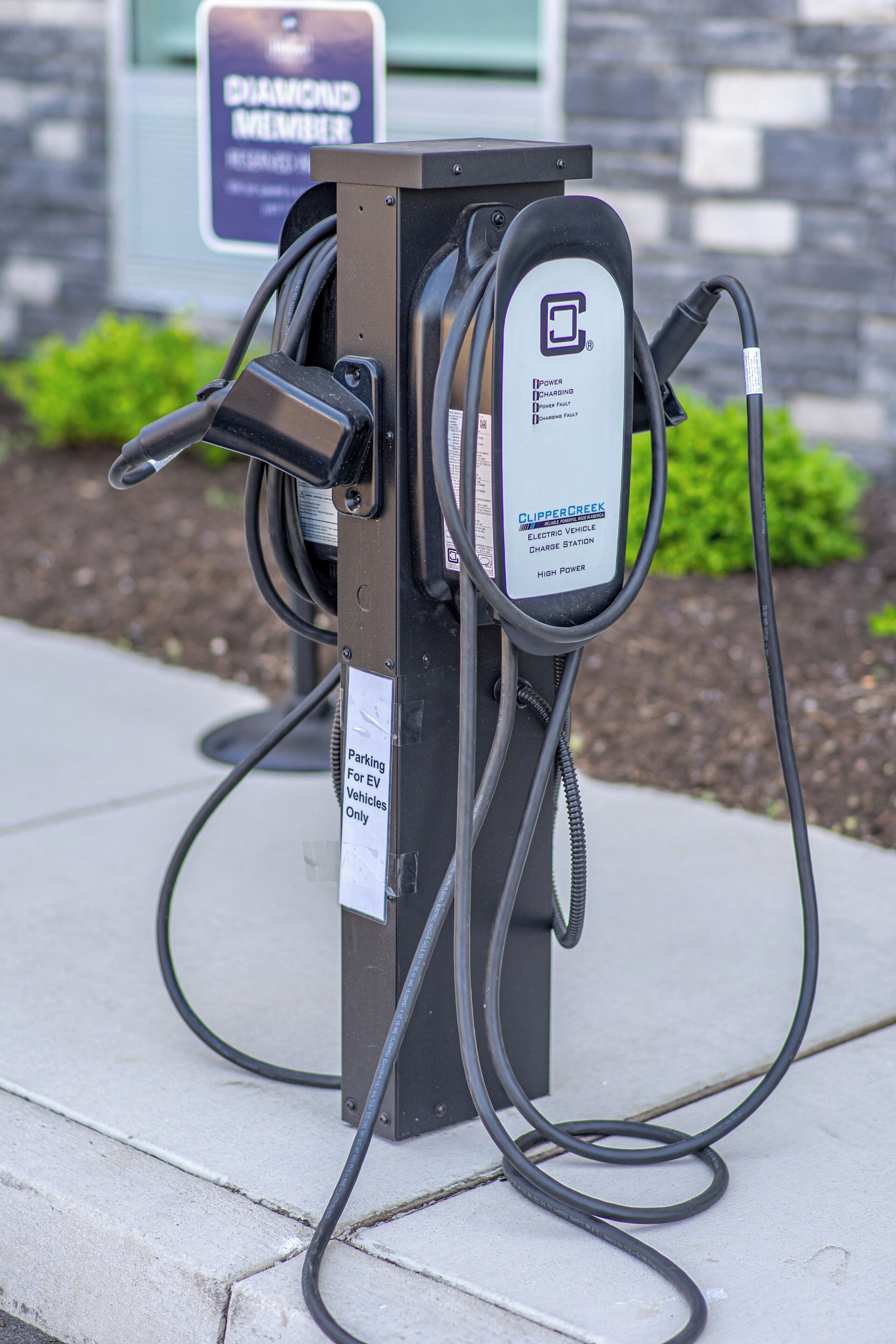 An electric vehicle charging station with a sign indicating it is for EV vehicles only.