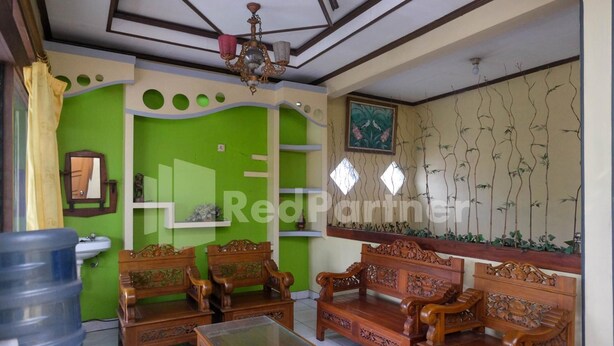 Una habitación con paredes verdes, muebles de madera, un dispensador de agua grande y un techo decorativo.