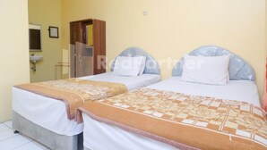 Una habitación con dos camas, un armario de madera, un lavamanos y un espejo.