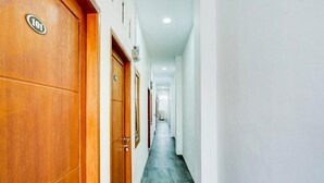 A hallway with wooden doors, each marked with a number. - OYO 4009 Jabusimo Syariah (Jakarta)