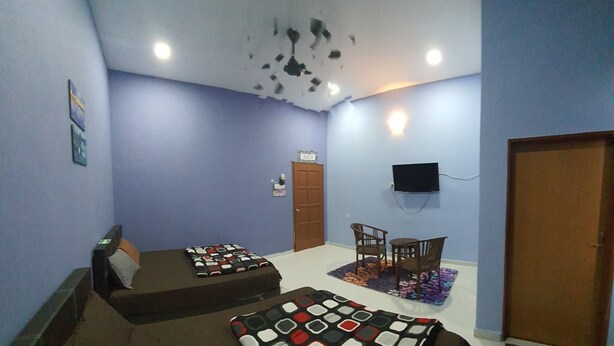 A room with two beds, a TV mounted on the wall, and a door. - Hotel O Penginapan Wahee (Kuala Terengganu)