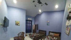 A room with two beds, a TV, and a dining area with a table and chairs. - Hotel O Penginapan Wahee (Kuala Terengganu)
