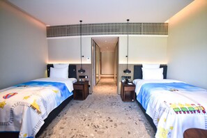 Une chambre d’hôtel avec deux lits, un couloir et une bouche d’aération au plafond.