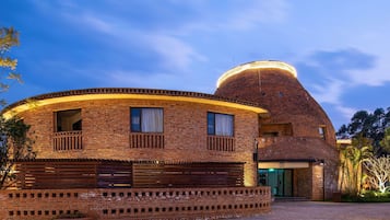 Un edificio de ladrillo con fachada curva, una estructura en forma de cúpula y una entrada porticada.