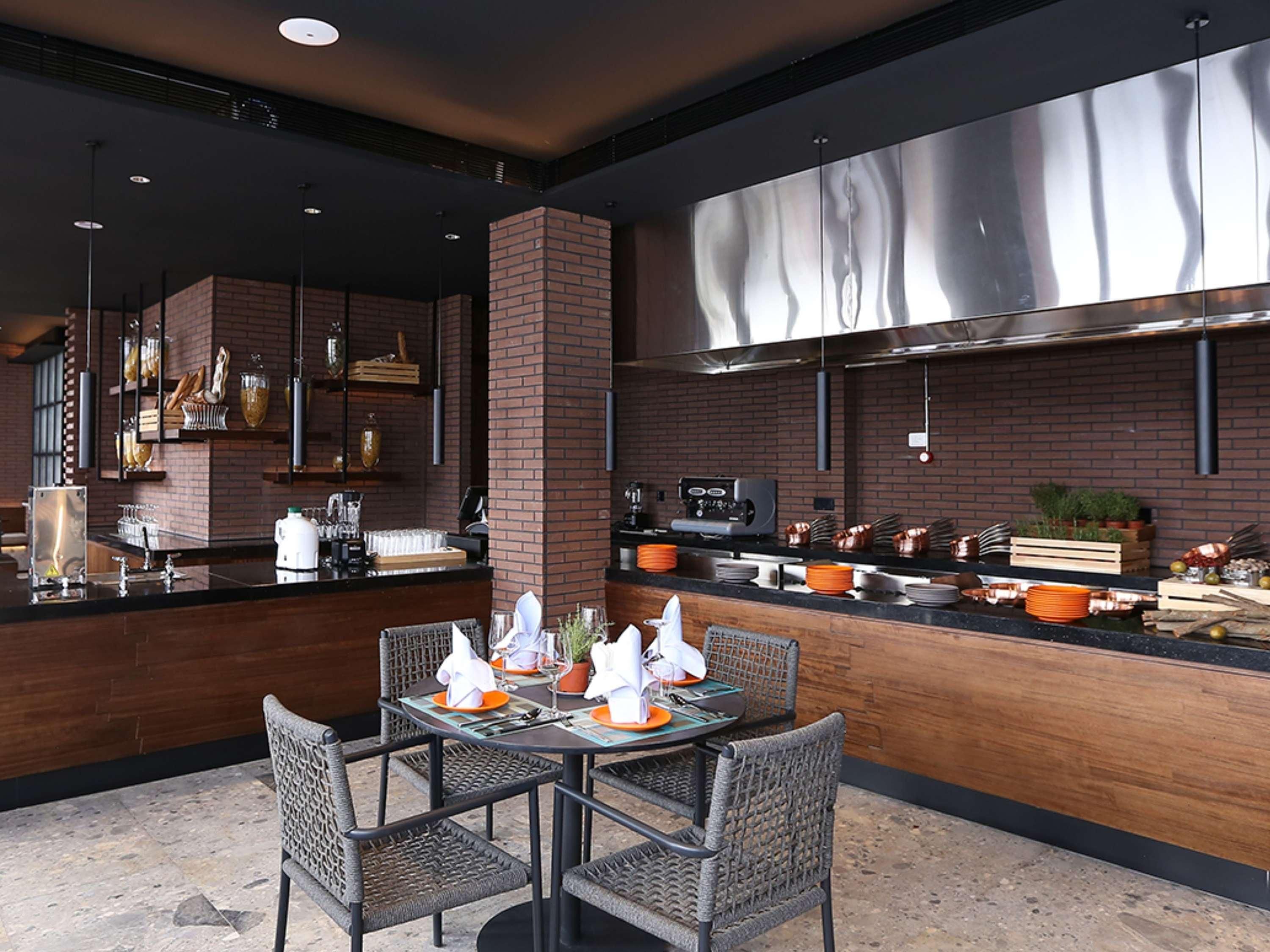 Una cocina moderna con paredes de ladrillo, electrodomésticos de acero inoxidable y una barra con asientos.