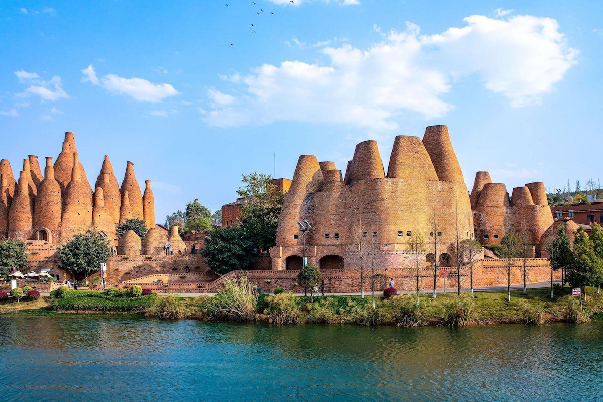 A historic building with unique conical architecture by a body of water.