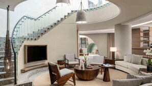 Una sala de estar moderna con una escalera curva, una chimenea y una zona de estar acogedora.