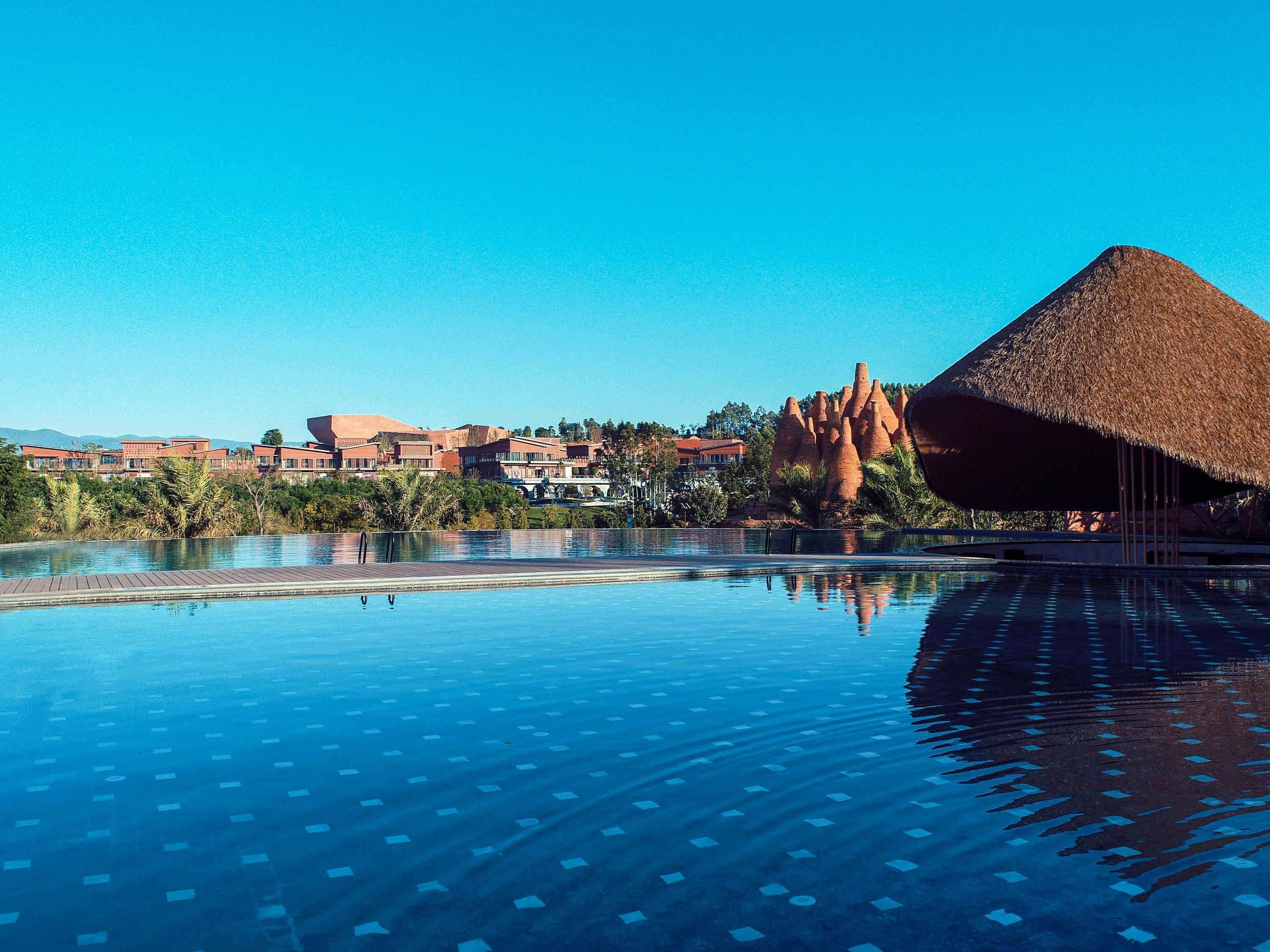 Ein Resort-Pool mit freiem Blick auf die umliegenden Gebäude und natürliche Felsformationen.