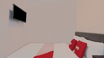 A modern hotel room with a flat-screen TV mounted on the wall, a neatly made bed with white and red bedding, and a grey headboard.