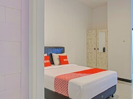 Una habitación de hotel con una cama, un armario y un espejo.