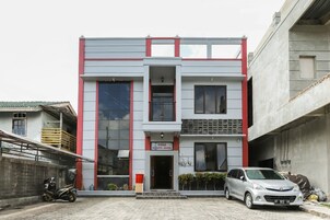 A two-story building with a flat facade, large windows, and a red and grey color scheme.