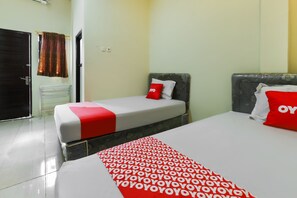 Une chambre d’hôtel avec deux lits, une salle de bain et une porte.