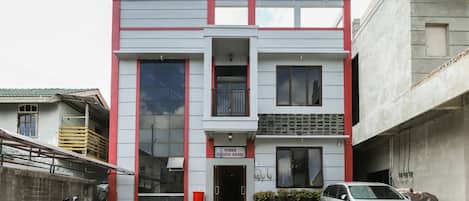 A two-story building with a flat facade, large windows, and a red and grey color scheme.