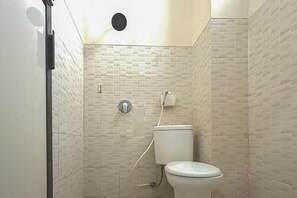 Un bagno con il water, una doccia e un lavandino a parete.