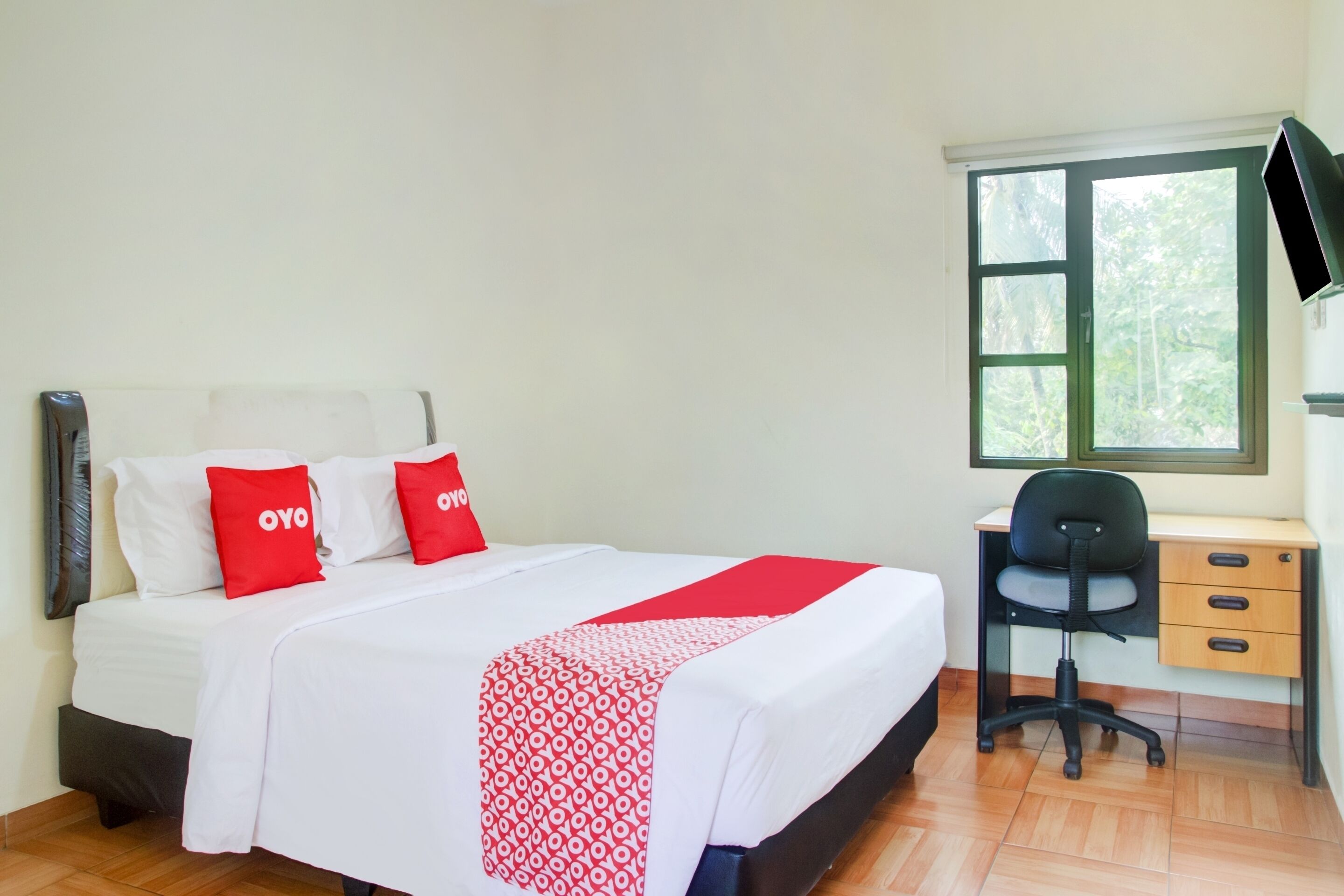 Una habitación de hotel con una cama, un escritorio y una silla.