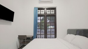 Ein Hotelzimmer mit Bett, Schreibtisch, Stuhl und Fernseher.