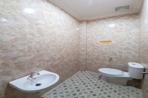 Casa de banho com lavatório, sanita e mosaicos no chão.