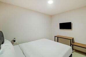 A hotel room with a bed, a bedside table, a TV mounted on the wall, and a power outlet. - Collection O Kebon Jeruk Near Paskal 23 (Bandung)