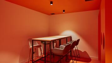 A conference room with a rectangular table and six chairs, illuminated by ceiling lights.