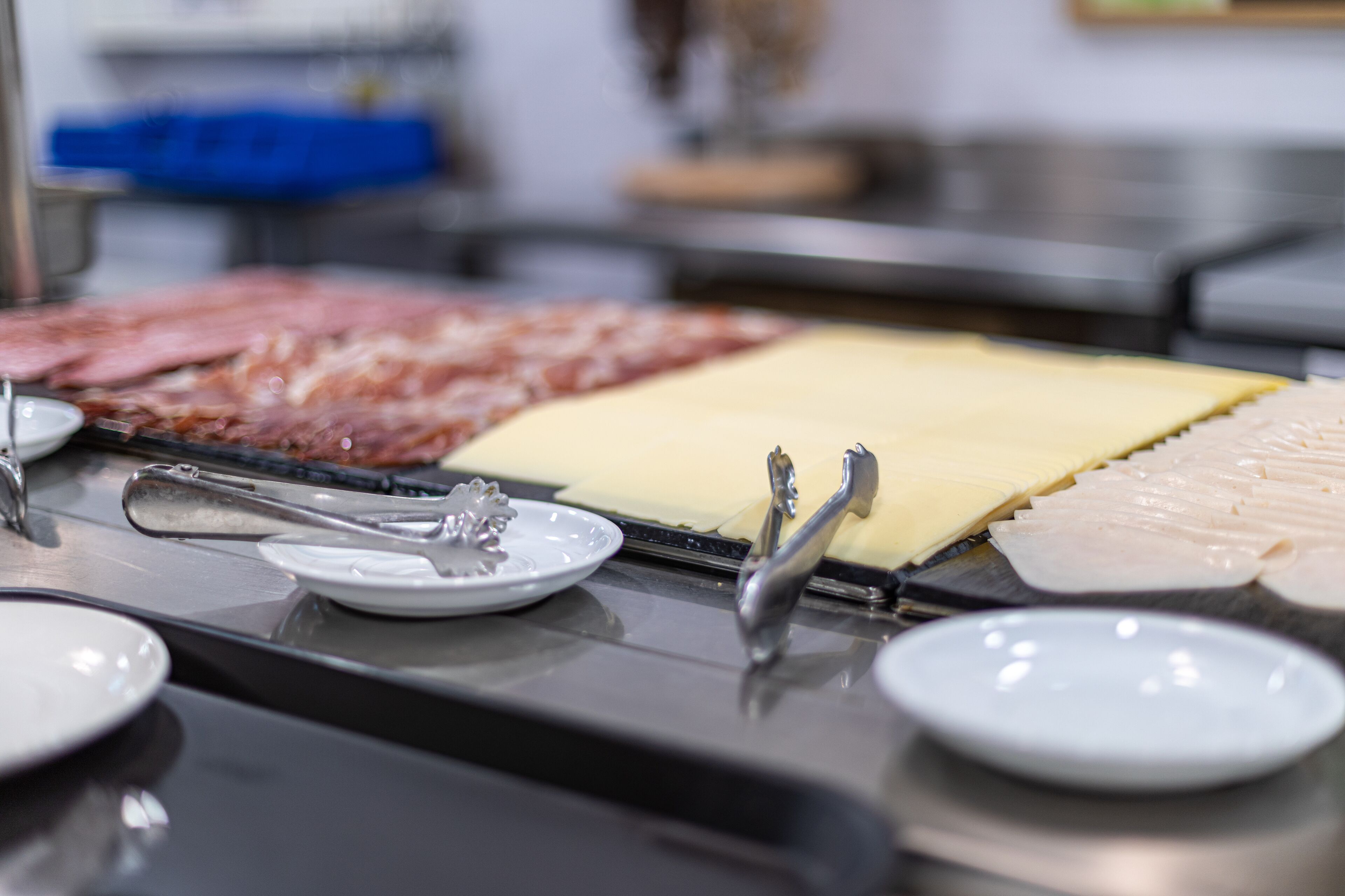 A food station with various meats and cheeses.