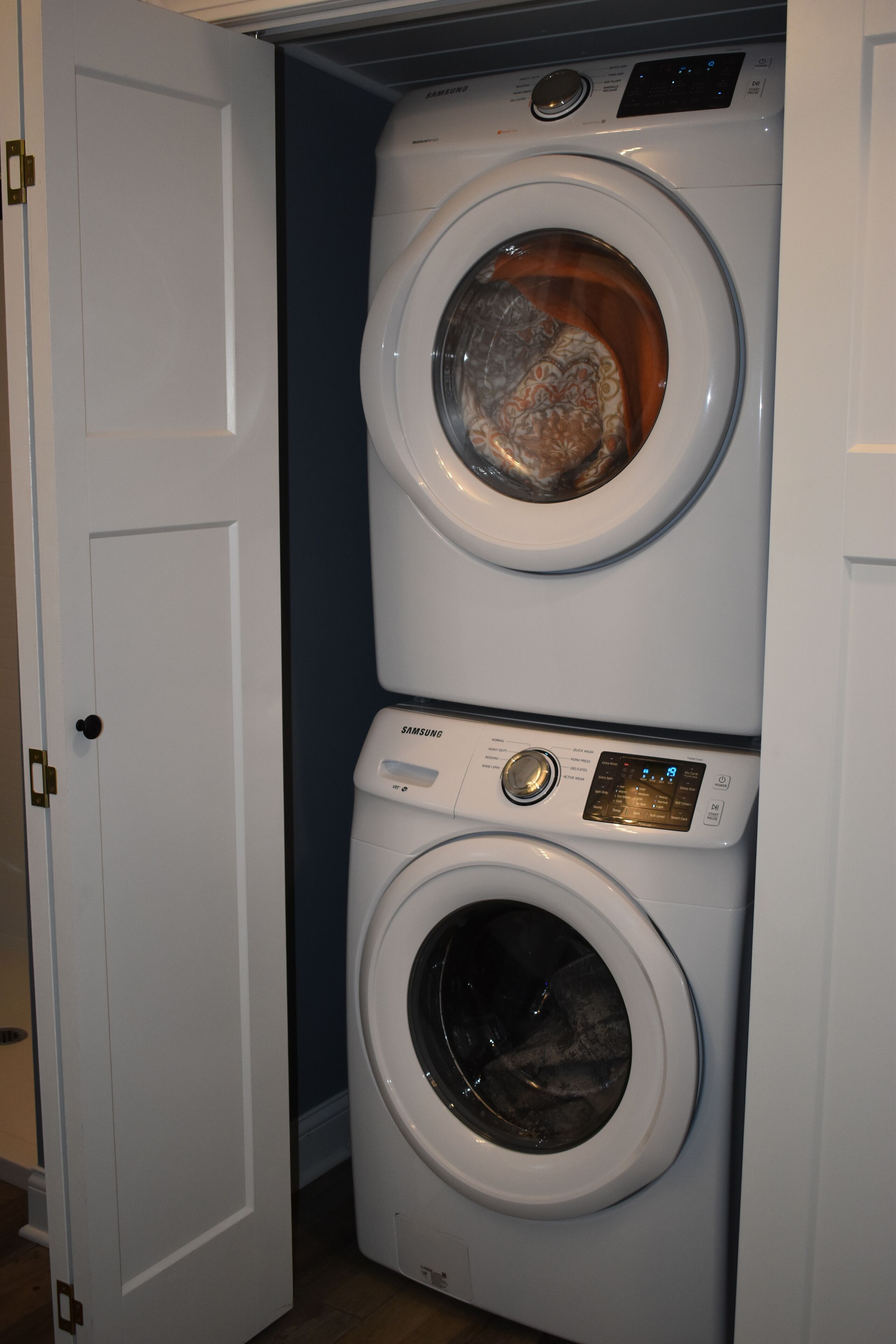 A stacked washer and dryer unit in a laundry room.
