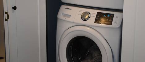 A stacked washer and dryer unit in a laundry room.