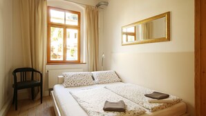 A bedroom with a bed, a chair, a window, and a mirror. - Stylishly furnished apartment in Dresden including bicycles, close to the center (Dresden)