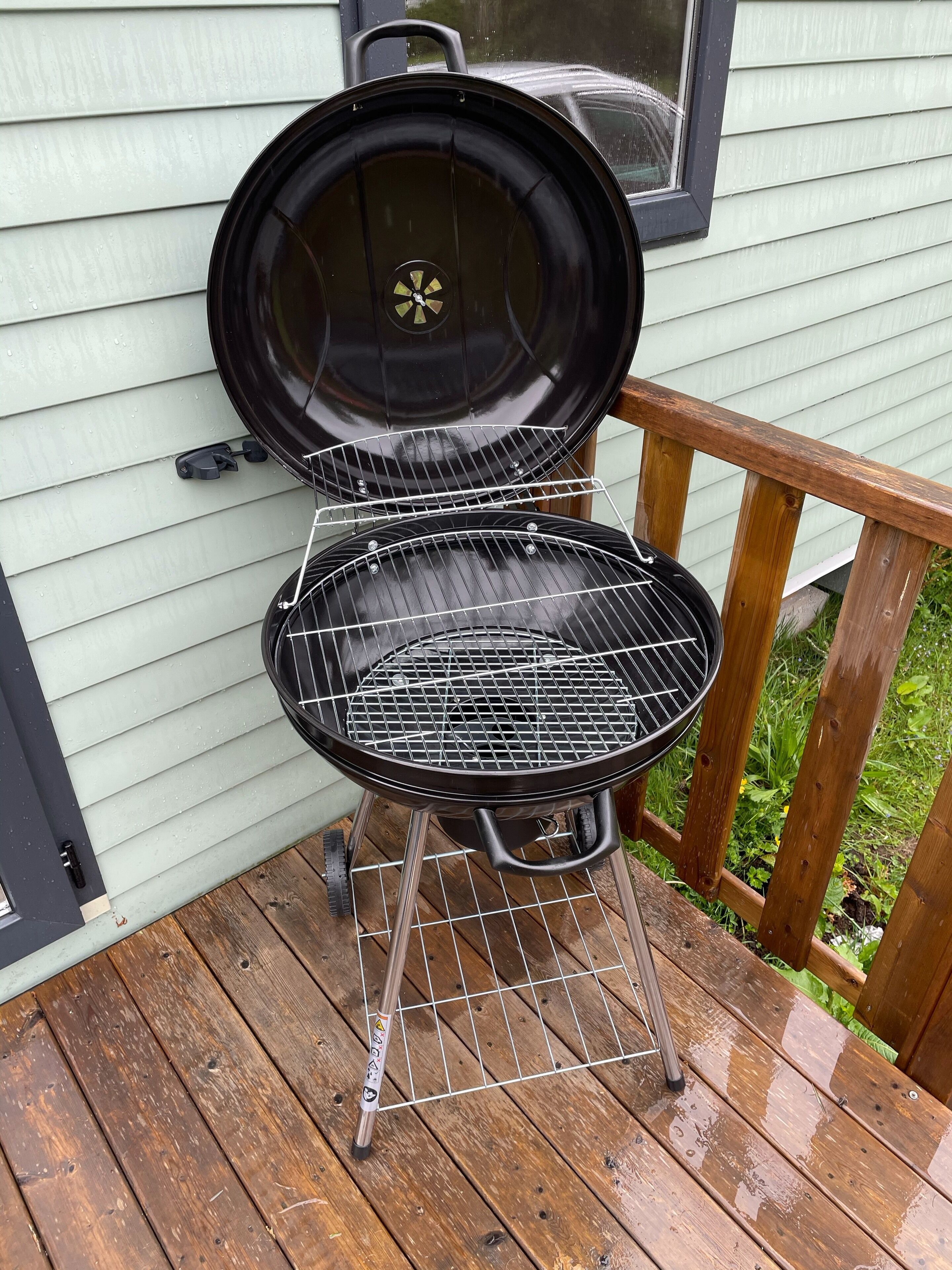 A portable grill on a wooden deck.