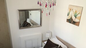 A hotel room with a large bed, a mirror, a chandelier, and a painting on the wall. - Laines Loft - cosy flat in the centre of The Laines, with private sun terrace (Brighton)