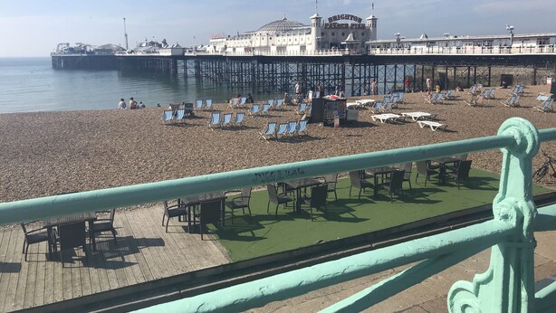 A beach with sun loungers and a pier in the background. - Laines Loft - cosy flat in the centre of The Laines, with private sun terrace (Brighton)
