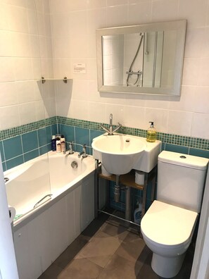 A bathroom with a bathtub, a sink, and a toilet. - Laines Loft - cosy flat in the centre of The Laines, with private sun terrace (Brighton)