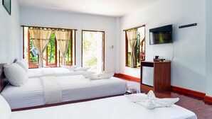 A hotel room with two beds, a TV, and a desk.