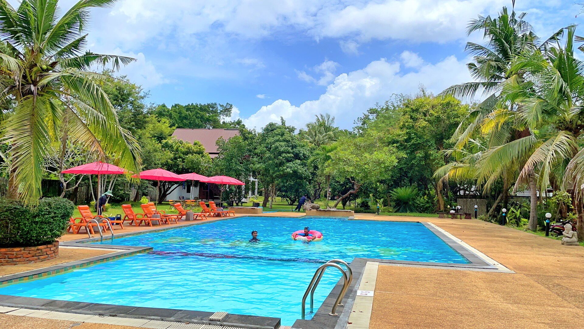 Una piscina al aire libre, sombrillas, tumbonas